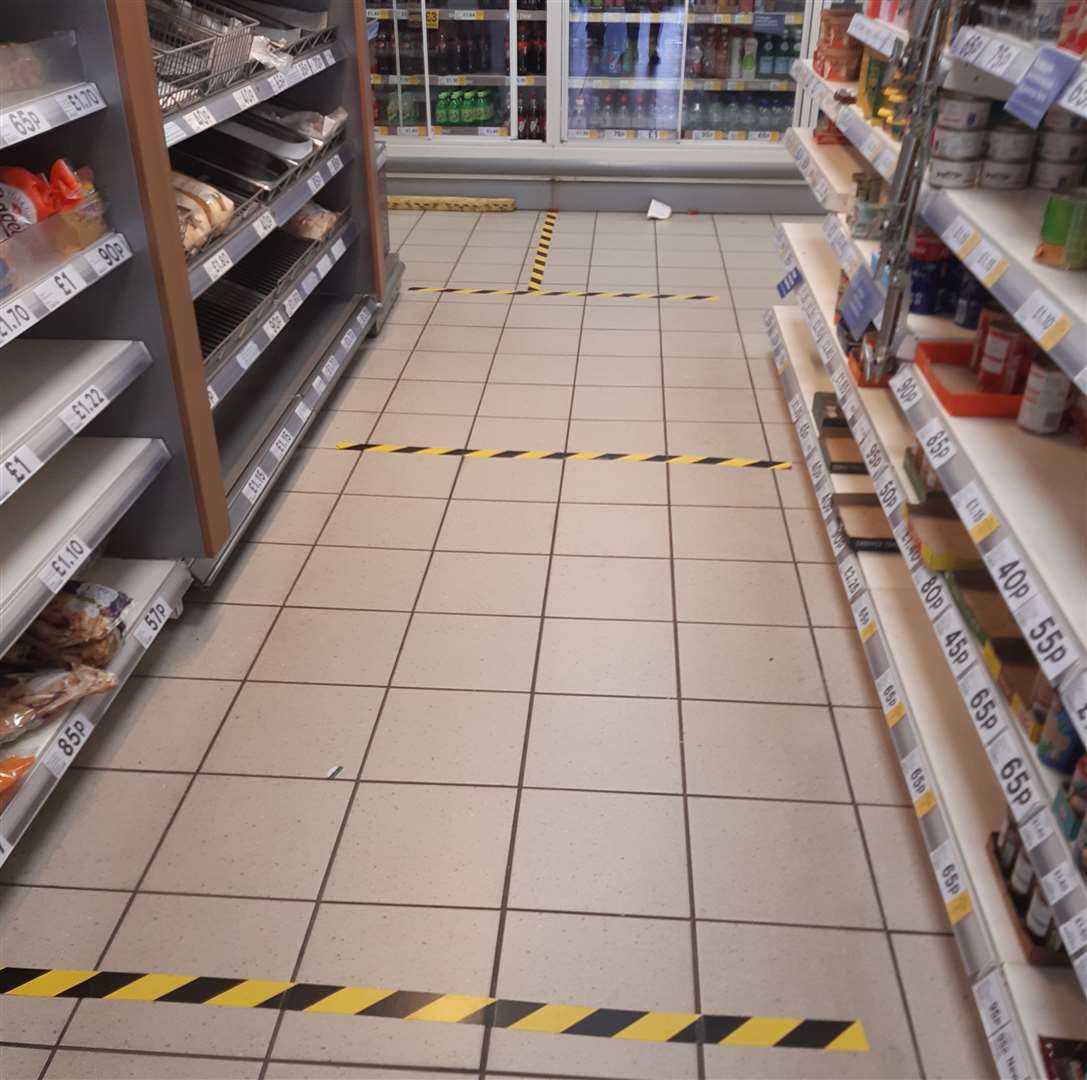 Hazard squares marked out with tape on the floor of Tesco Express