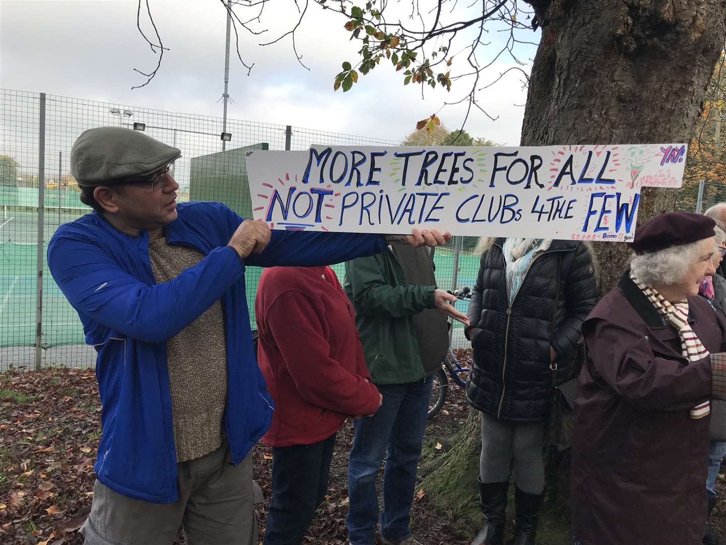 Peter Sean holds up a sign protesting the tree's planned demise