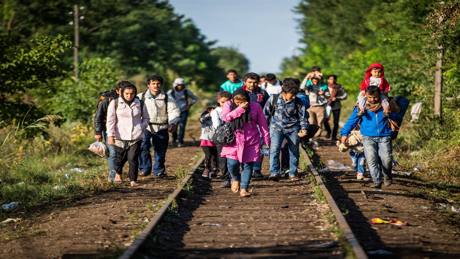 A group of refugees walk railway lines to cross the border to Hungary from Serbia. Picture: SWNS.com