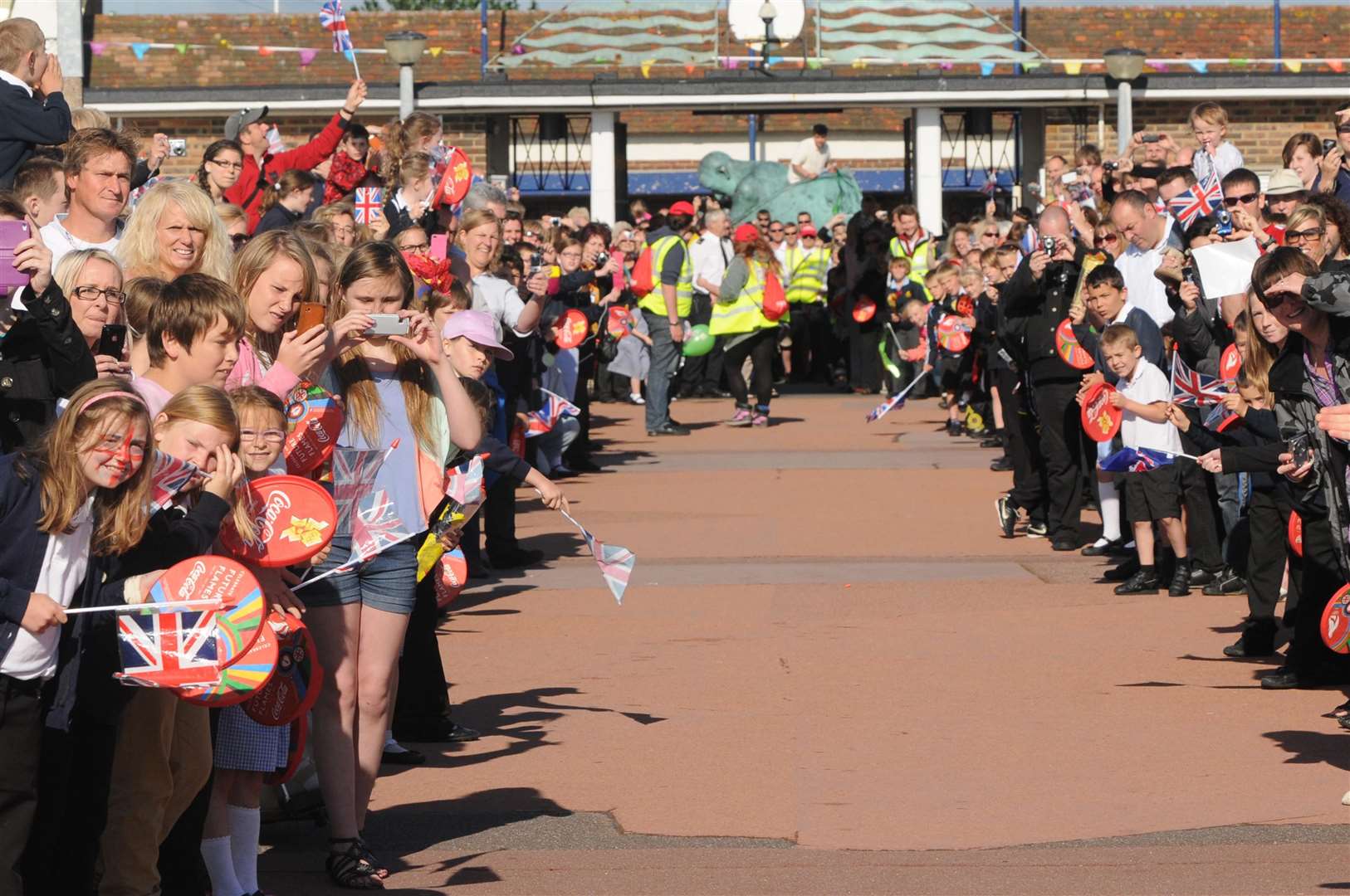 Heads turn towards the end of Deal pier as torchbearer Kathy Batts heads for the entrance