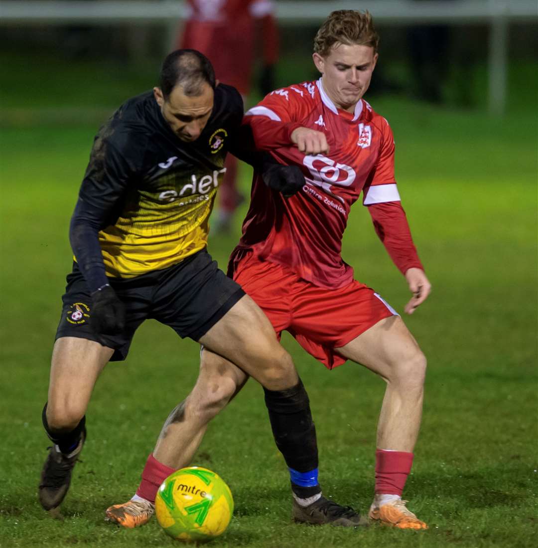 Nathan Wood, of Faversham, does battle with Larkfield & New Hythe's Jack Sammoutis during Tuesday night’s Challenge Cup tie which the Lilywhites edged 1-0. Picture: Ian Scammell
