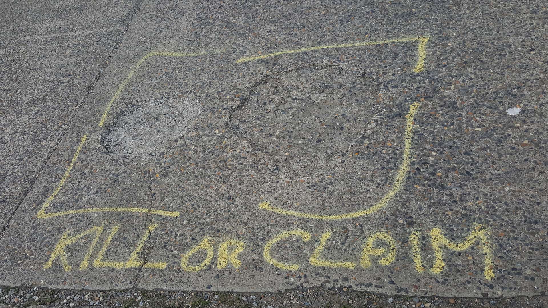 An angry resident has labelled potholes on the road with the words 'KILL OR CLAIM'