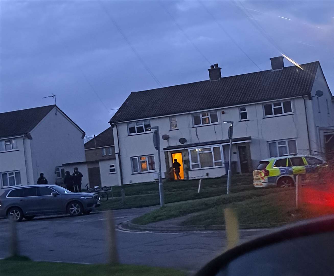 Armed officers entering a house on the residential street