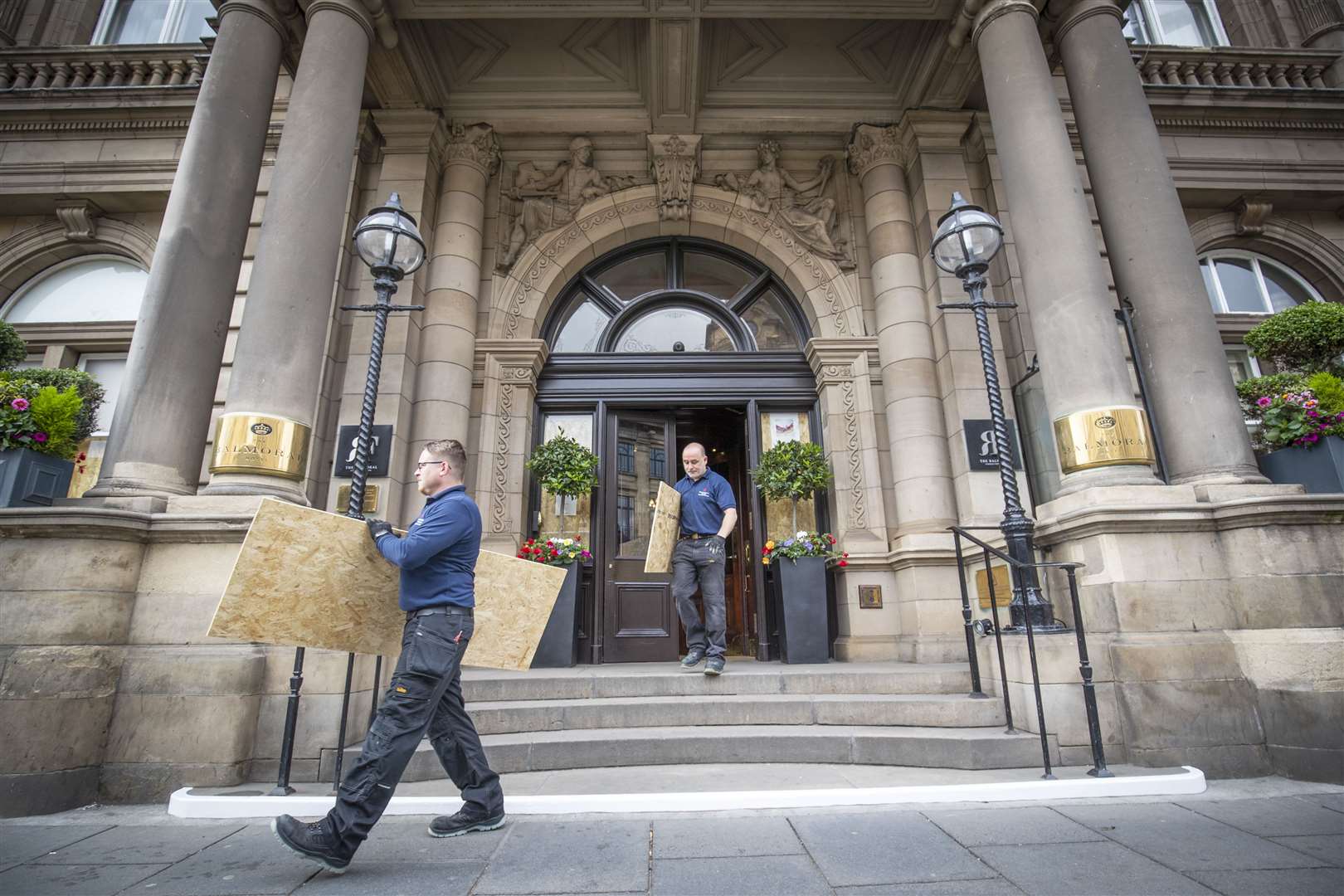 The maintenance team at The Balmoral, Edinburgh, remove boards from the front door as the hotel starts to make preparations for reopening next month (Jane Barlow/PA)