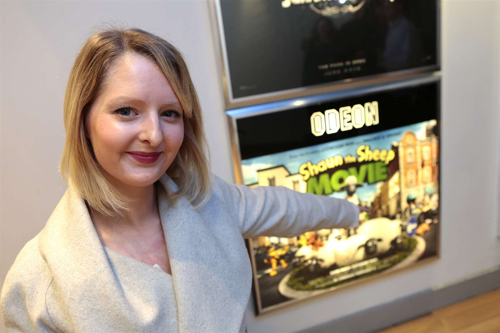 Emma with the poster for the film she worked on, Shaun the Sheep