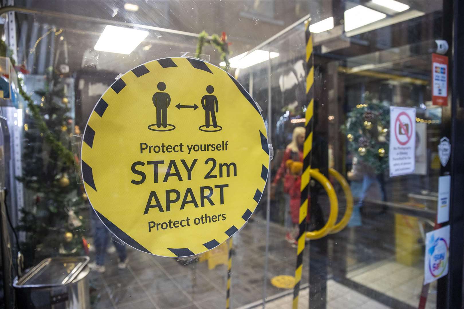 Signage on the window of Pic and Mix Body Jewellery Shop in Belfast asking customers to social distance and protect yourself and others by staying 2m apart. (Liam McBurney/PA)