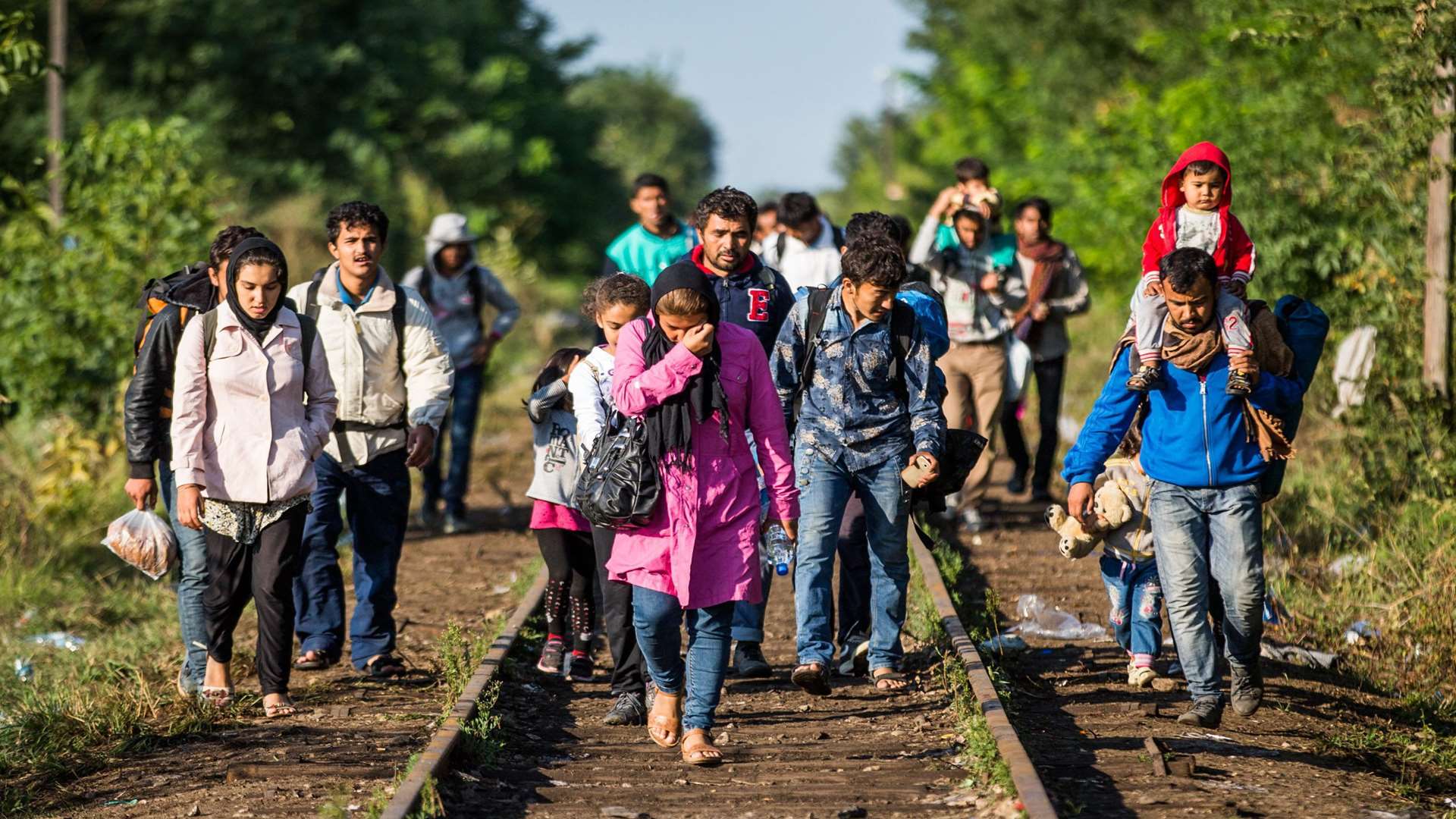 A group of refugees walk railway lines to cross the border to Hungary from Serbia. Picture: SWNS.com