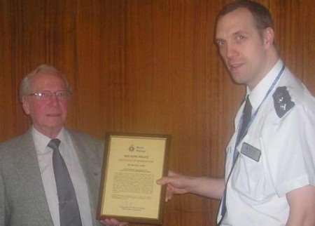 Michael Lowe receiving his award from Ch Inspector Mark Chambers