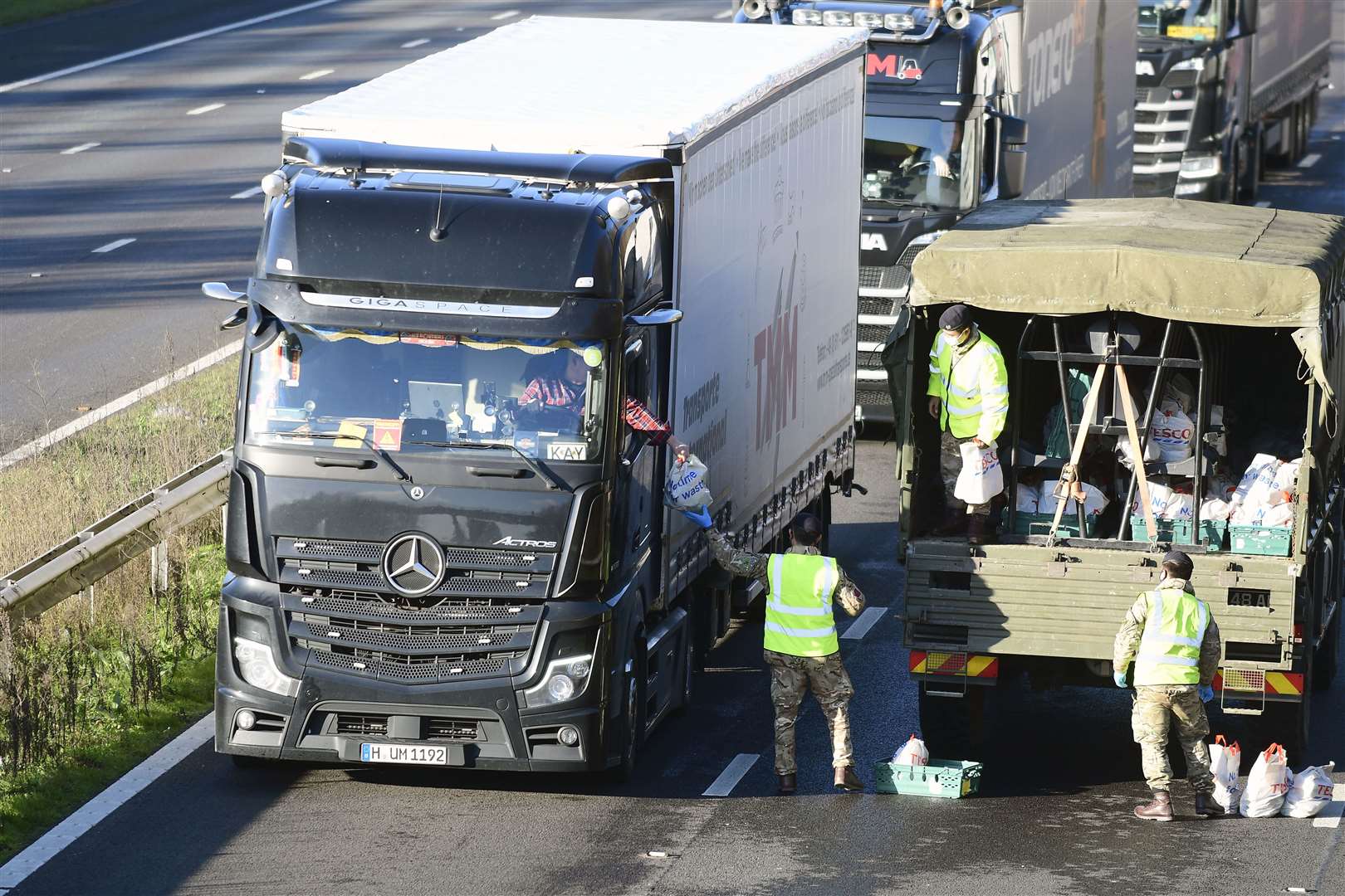 Army soldiers hand out food and water to the stranded drivers on the M20 between junction 10a and 11 Pic: Barry Goodwin