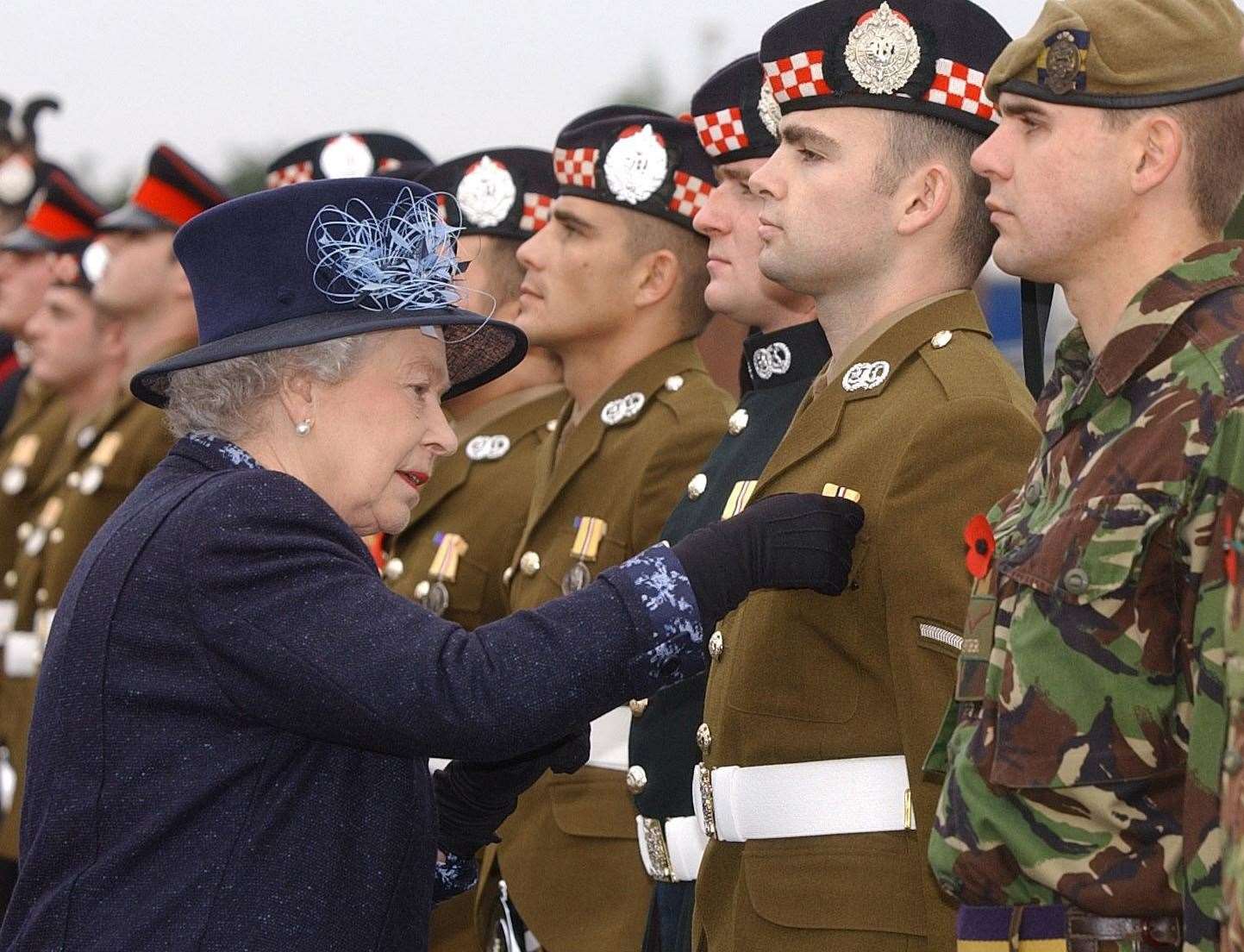 Queen Elizabeth II presents an Operational Service Medal to Lance Corporal Gary Smith at Howe Barracks in Canterbury, Tuesday, November 9, 2004. Picture: Kirsty Wigglesworth PA