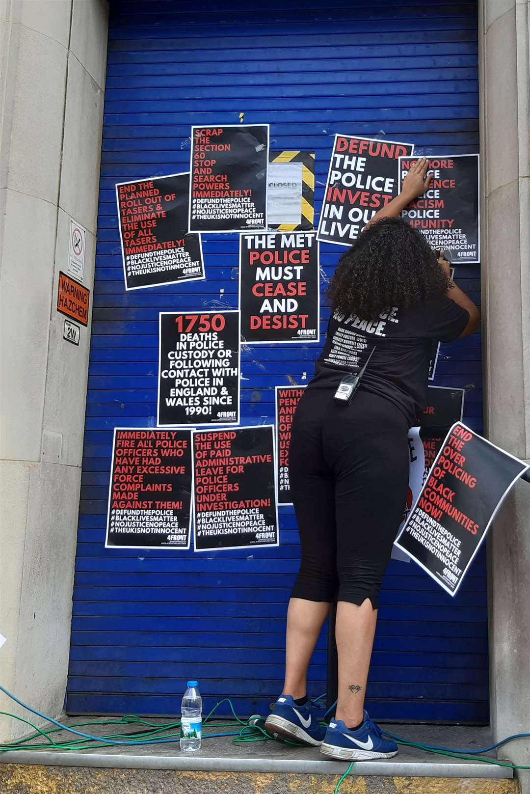 A protester hangs posters during the rally (Helen William/PA)