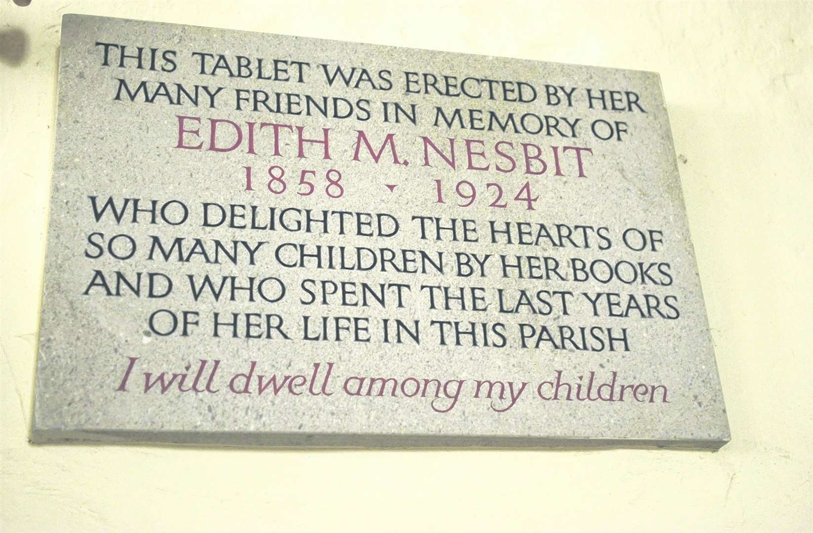 A memorial inside St Mary the Virgin Church in St Mary in the Marsh to author Edith Nesbit. Outside is a wooden grave marker erected by her husband