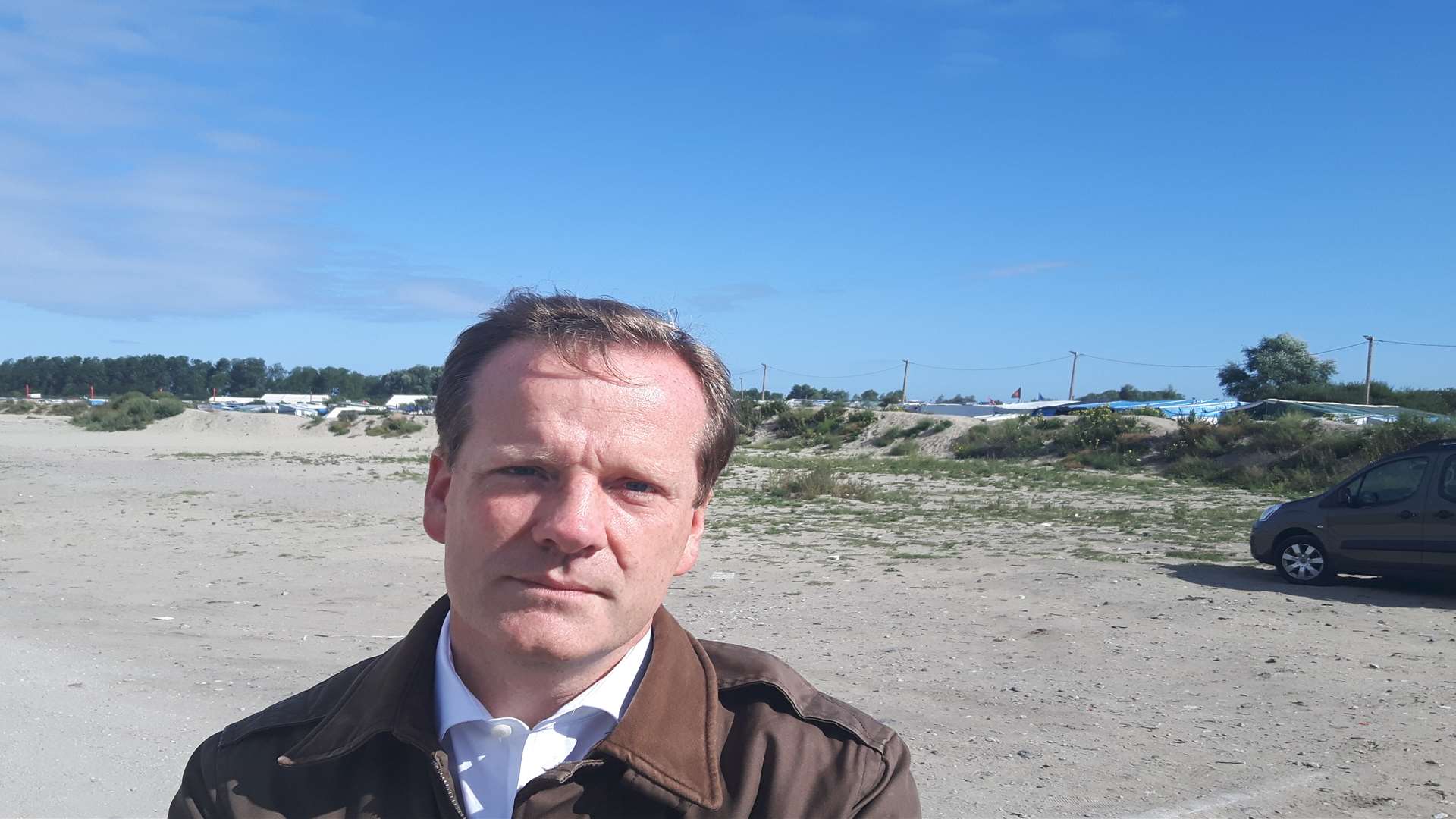 MP Charlie Elphicke outside the Jungle migrant camp last year