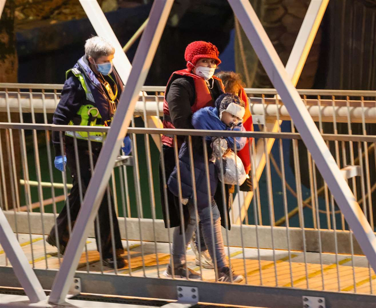 Two young children carried ashore at Dover after arriving on the Border Force boat Hurricane after being picked up near Ramsgate. Photo: UK News In Pictures