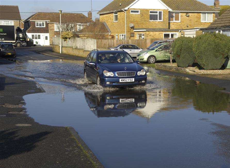 A car attempts to drive through a flooded road. File picture