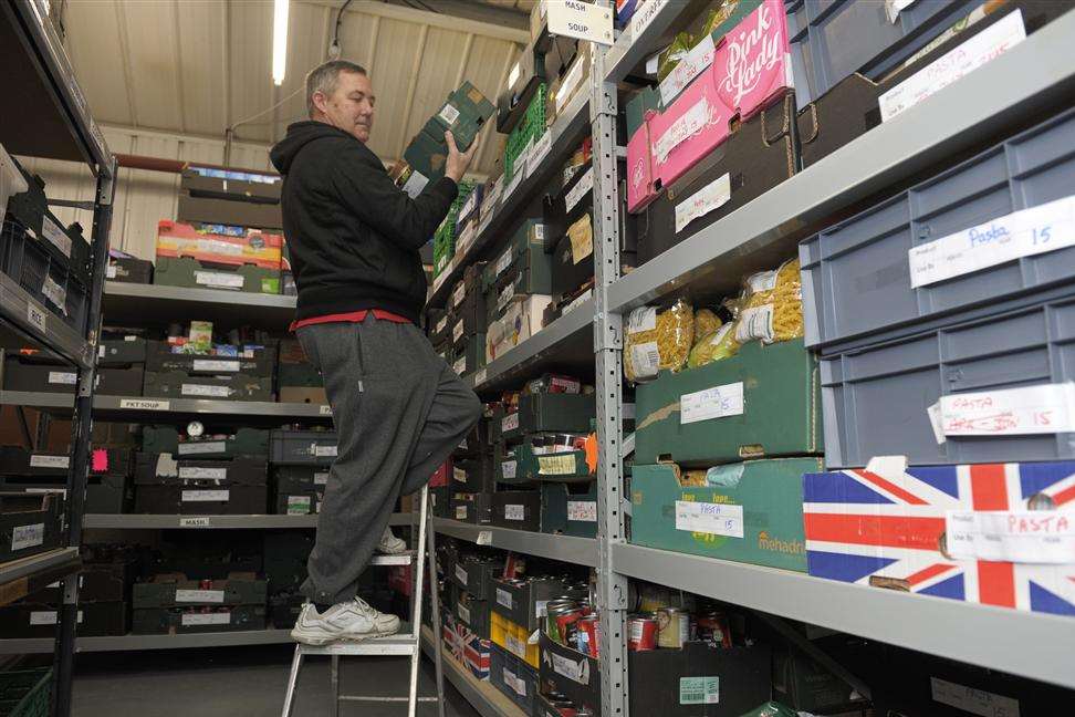 Ken Rose stacking cans at Medway Foodbank's warehouse in Strood