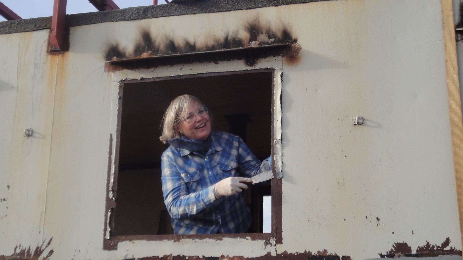 Frances Beaumont scraping the windows of the joliver tugboat which is now docked in Rochester