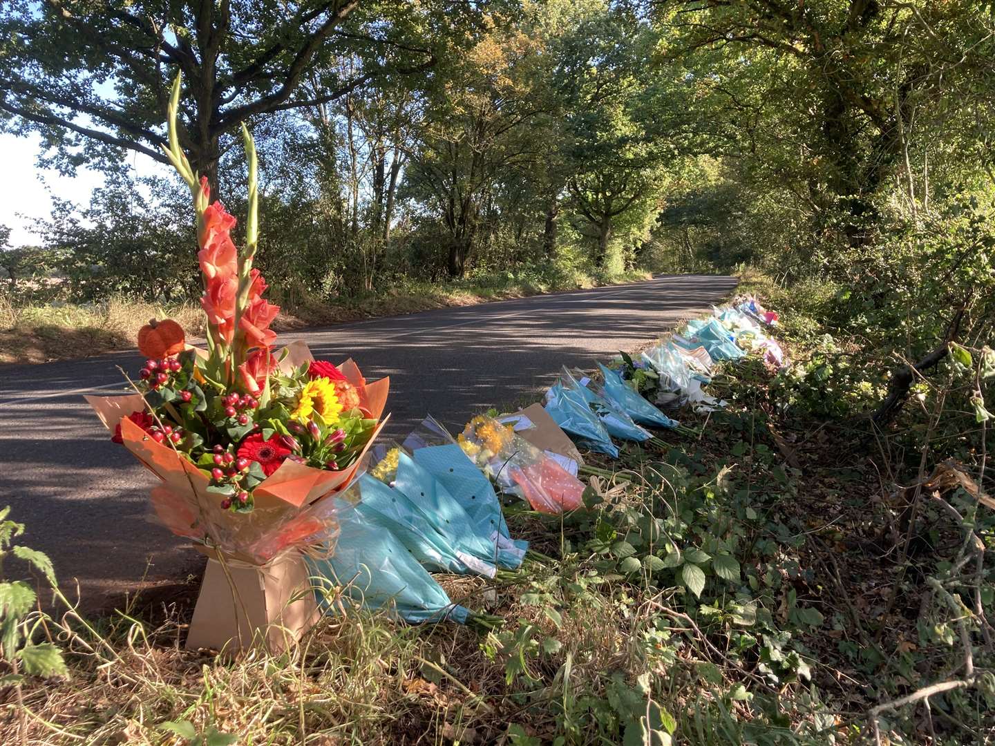 More than 50 floral tributes line Lenham Road, the scene of a crash which claimed four lives on Sunday, October 10