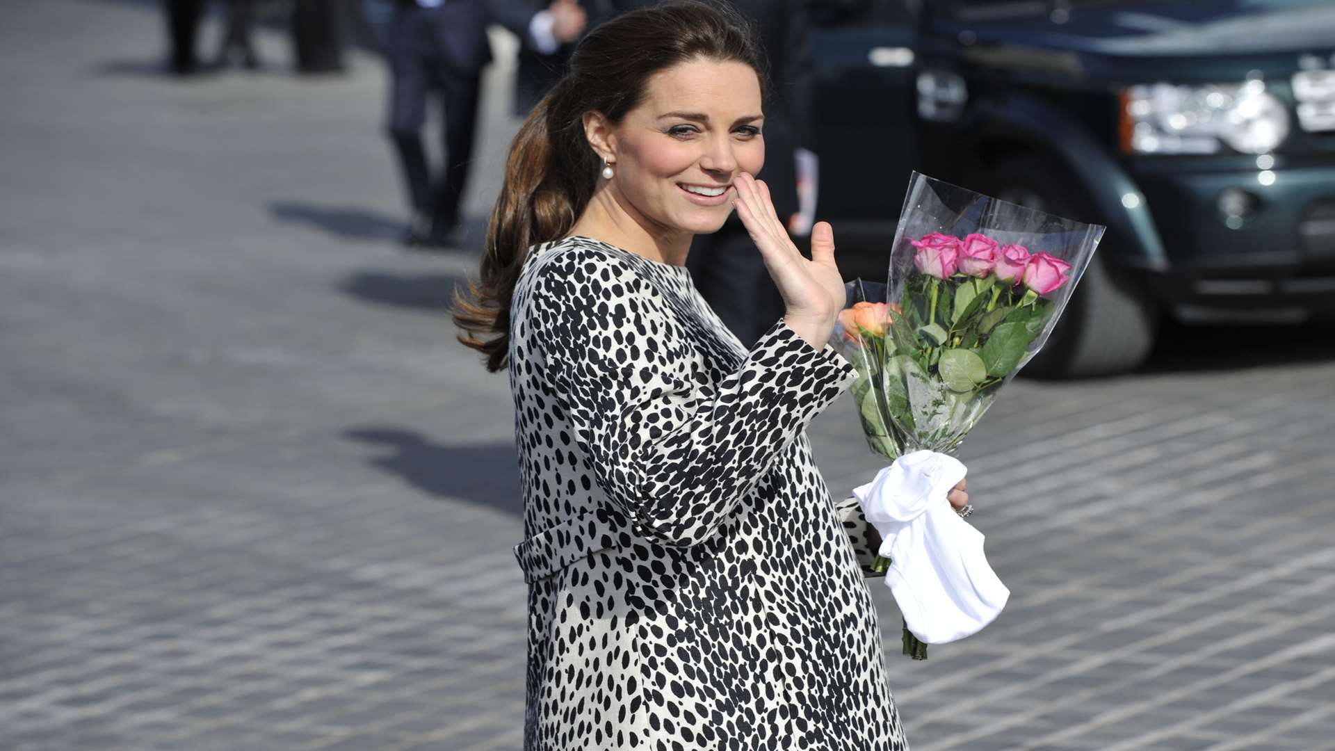Kate waves to crowds, holding a bouquet and the Thanet Extra's gift - a babygrow