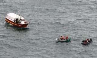 Rescuers approach the migrants, using a dinghy from their main vessel. Picture: préfecture maritime de la Manche et de la mer du Nord