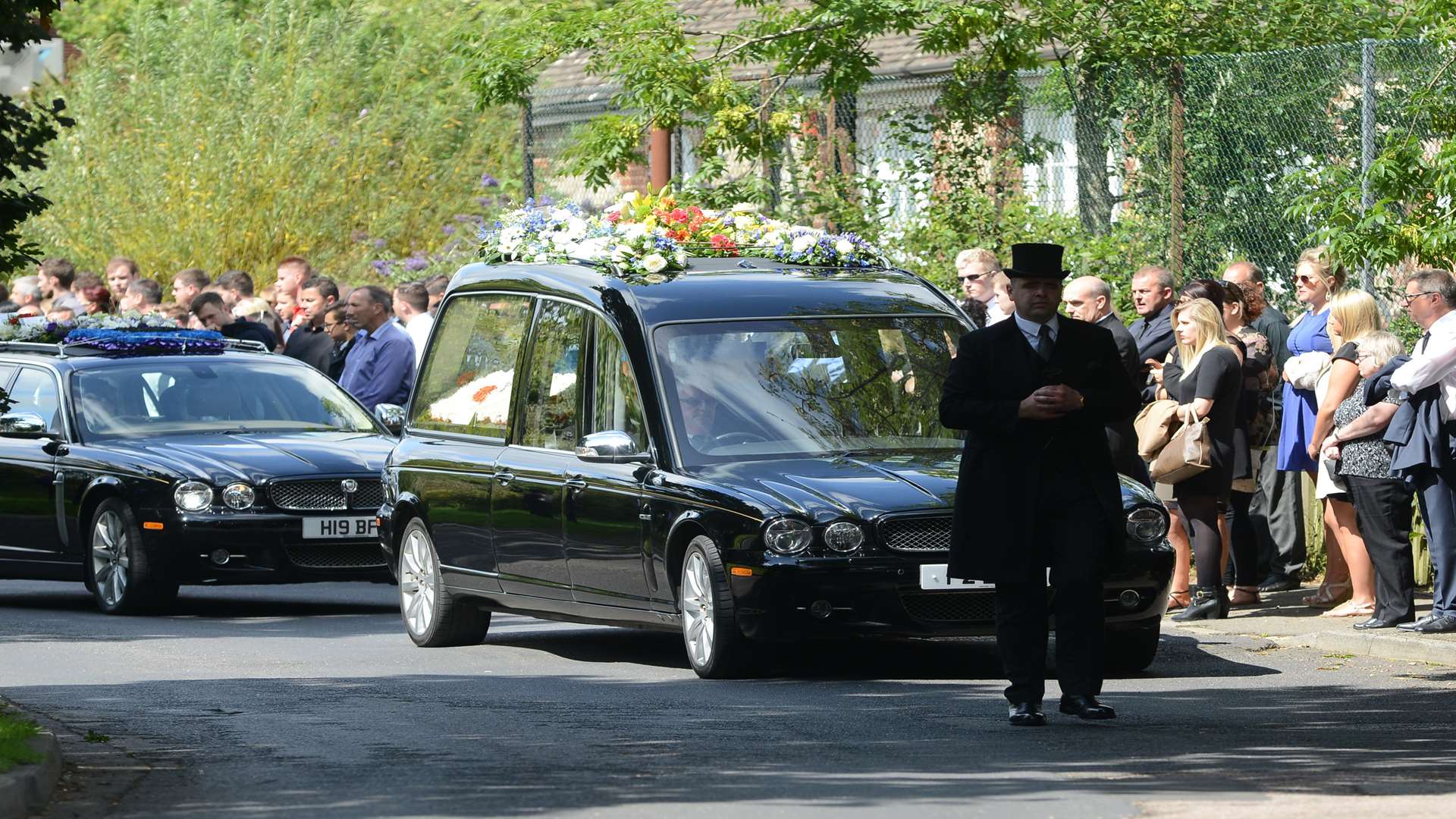 Mourners stood in silence as the hearse arrived