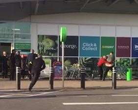 Security guards restrain a man at Asda in Greenhithe.