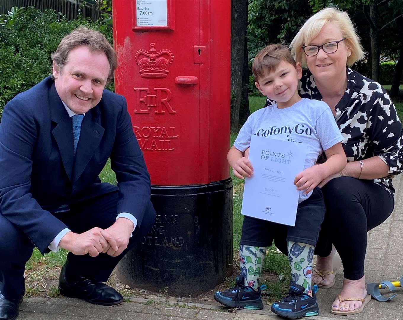 MP Tom Tugendhat presents Tony Hudgell, pictured with his mum Paula, with a reward from the Prime Minister