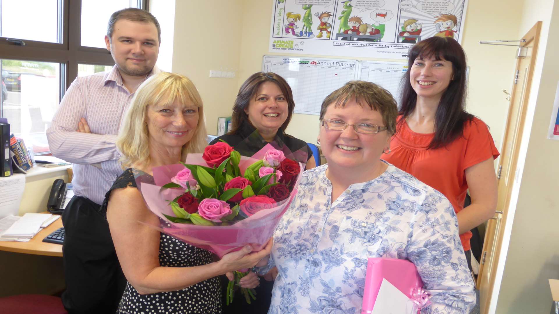 Louise Rogerson (front, left) and KM Charity Team staff present volunteer Brenda Loach with her retirement gifts.