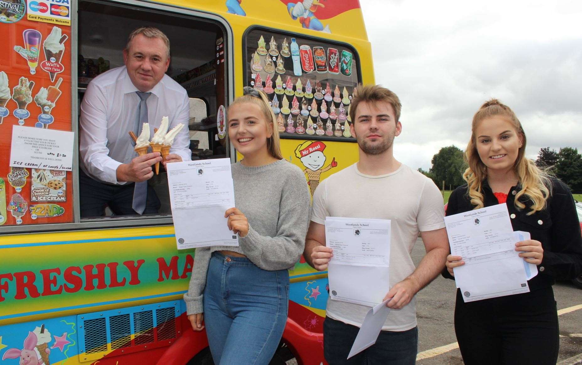 Head teacher Simon Cox hands out free ice creams at Westlands School, Sittingbourne, to pupils Megan Colverson, left, Harvey Pressnell and Hannah Taylor