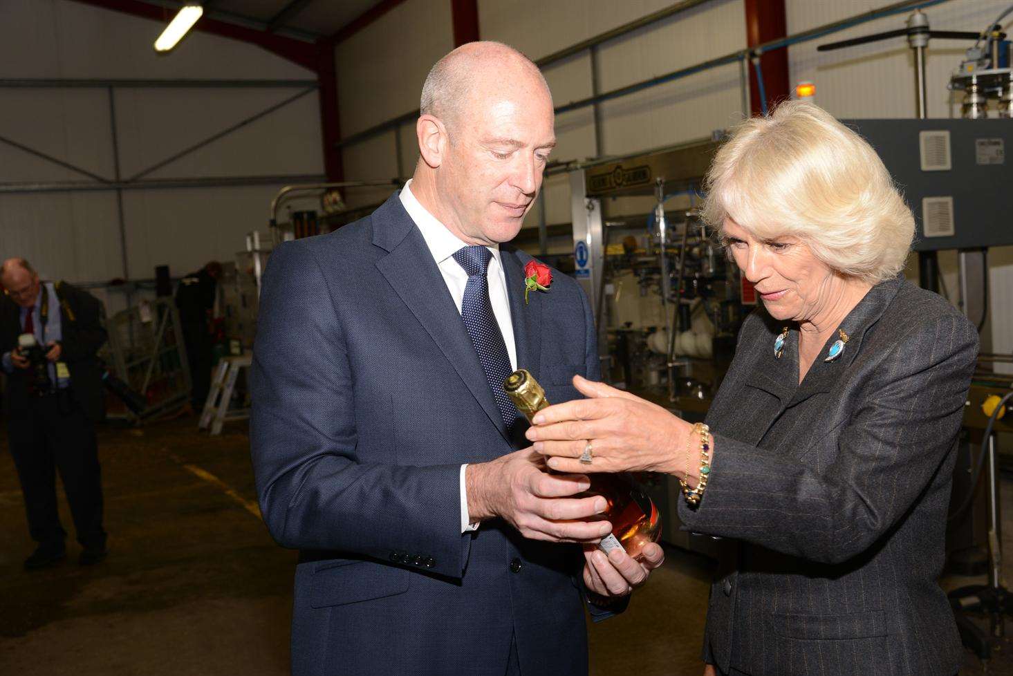 The Duchess of Cornwall receives a bottle of the special sparkling wine Cuvee Camilla from chief executive Frazer Thompson