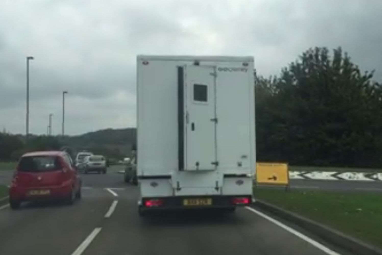 The door can be seen ajar as the van approaches a roundabout