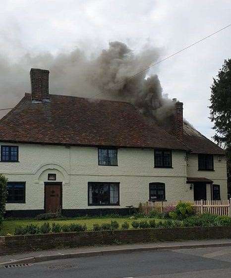 Smoke billows from the 16th century house on fire in Lynsted lane, Lynsted. Picture: Simon Cooper (8763586)