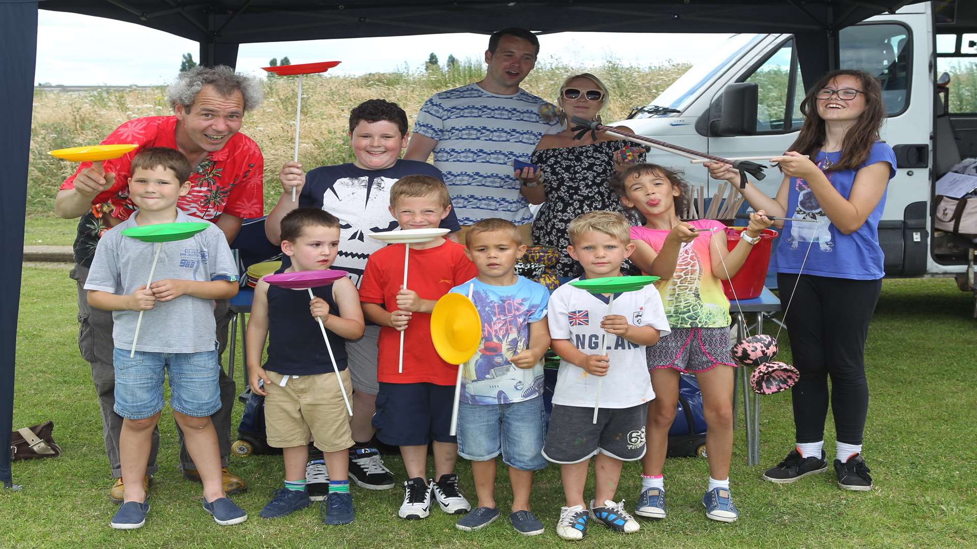 Tom from TK Arts left in red shirt with children with circus props at Milton Creek Country Park, in 2016