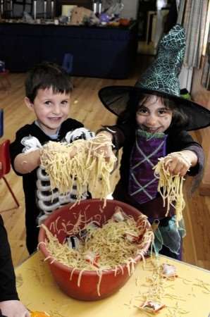 Gregory Schoen and Hannah Bennett make spider webs with spaghetti