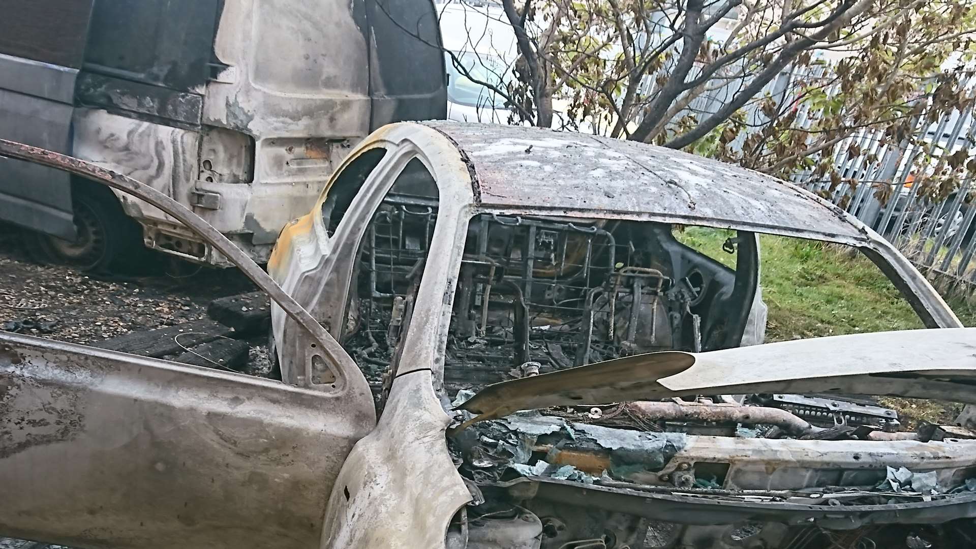The burnt out Micra and the VW Transporter