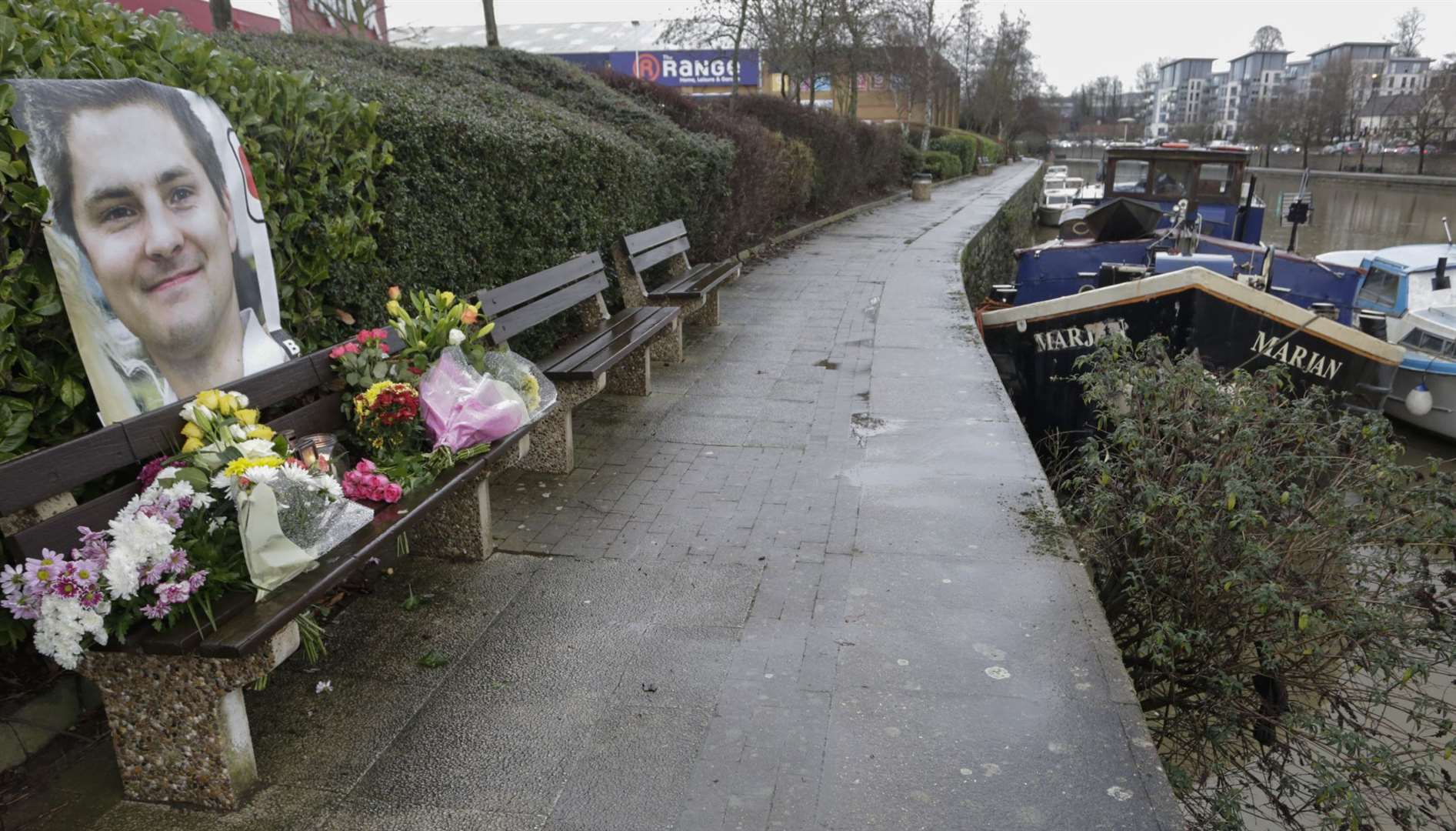 Floral tributes for Pat Lamb are placed on a bench in front of the river in Maidstone