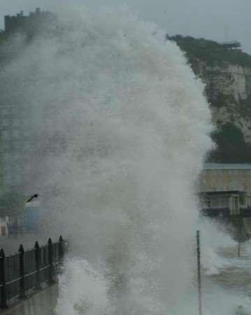 Another wave comes crashing ashore. Dover castle can just be seen top left. Picture: KM Group photographer TERRY SCOTT