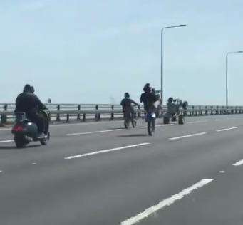 A group of youths were caught on video performing stunts on their motorbikes while crossing a bridge into Kent. (2738817)