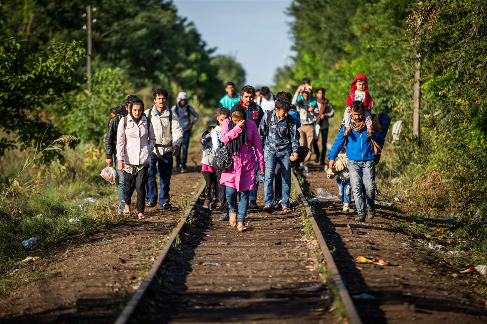 A group of migrants walk railway lines to cross the border to Hungary from Serbia. Picture: SWNS.COM