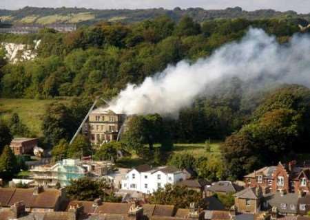 Smoke billows from the roof of the derelict building. Picture: NIGEL COLLOR