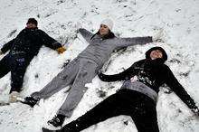 Guido Spocchia, Anna Box and Adelle Montgomery making snow angels at The Glen, Minster.