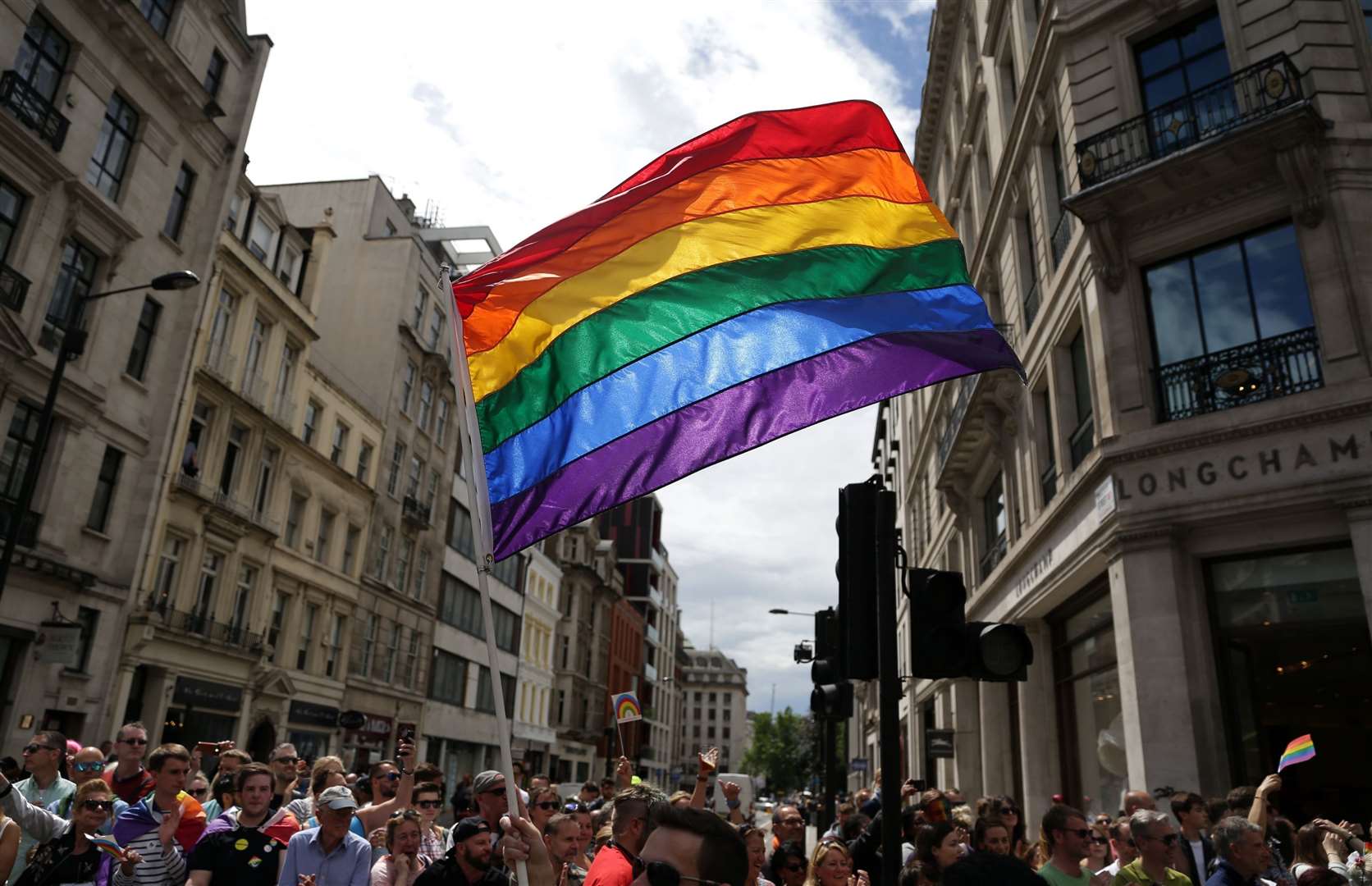 A rainbow flag is held aloft as a Pride in London parade makes its way through the streets. Picture: Daniel Leal-Olivas/PA Wire