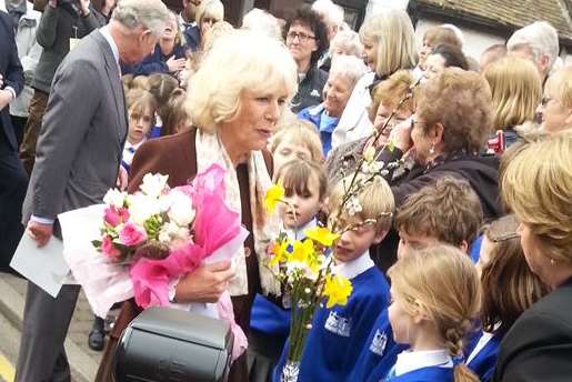 The Duchess of Cornwall is presented with flowers by children in Yalding as she arrives with Prince Charles
