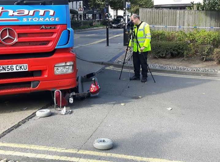 Police investigators examine the scene of mobility scooter crash