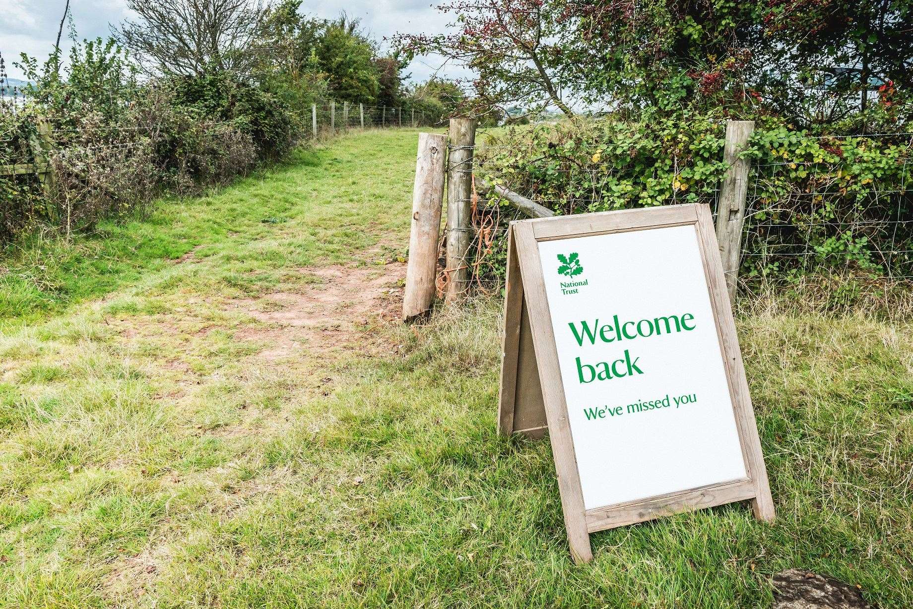 National Trust photo of a sign welcoming back visitors to the Lower Halsdon farm in Devon (Steve Sayers/PA)