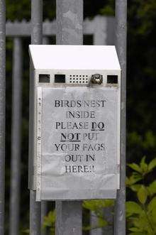 A sign where blue tits have been nesting in the cigarette box outside Coty UK Ltd