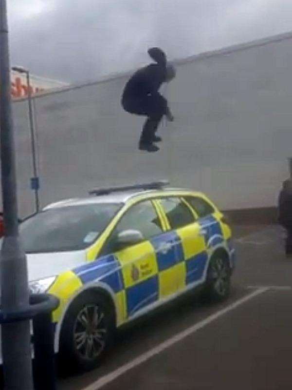 Stunned shoppers watched the yob jump up and down on the roof of the police car.