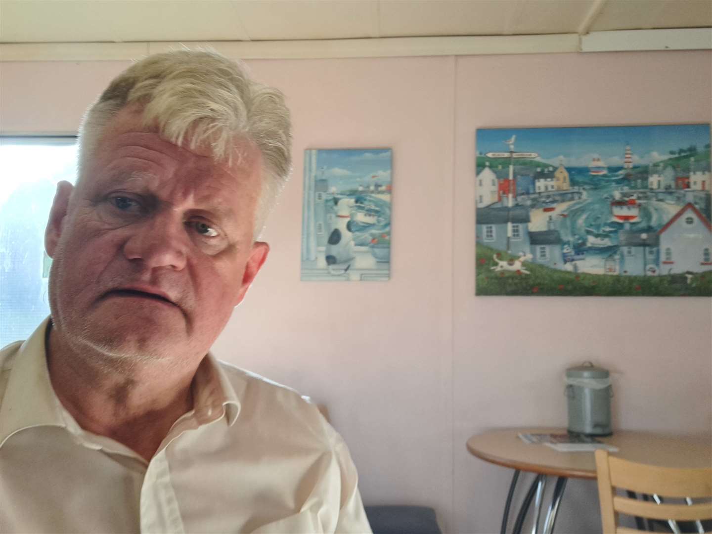 Reporter Sam Lennon at the Dover cafe with harbour paintings in the background