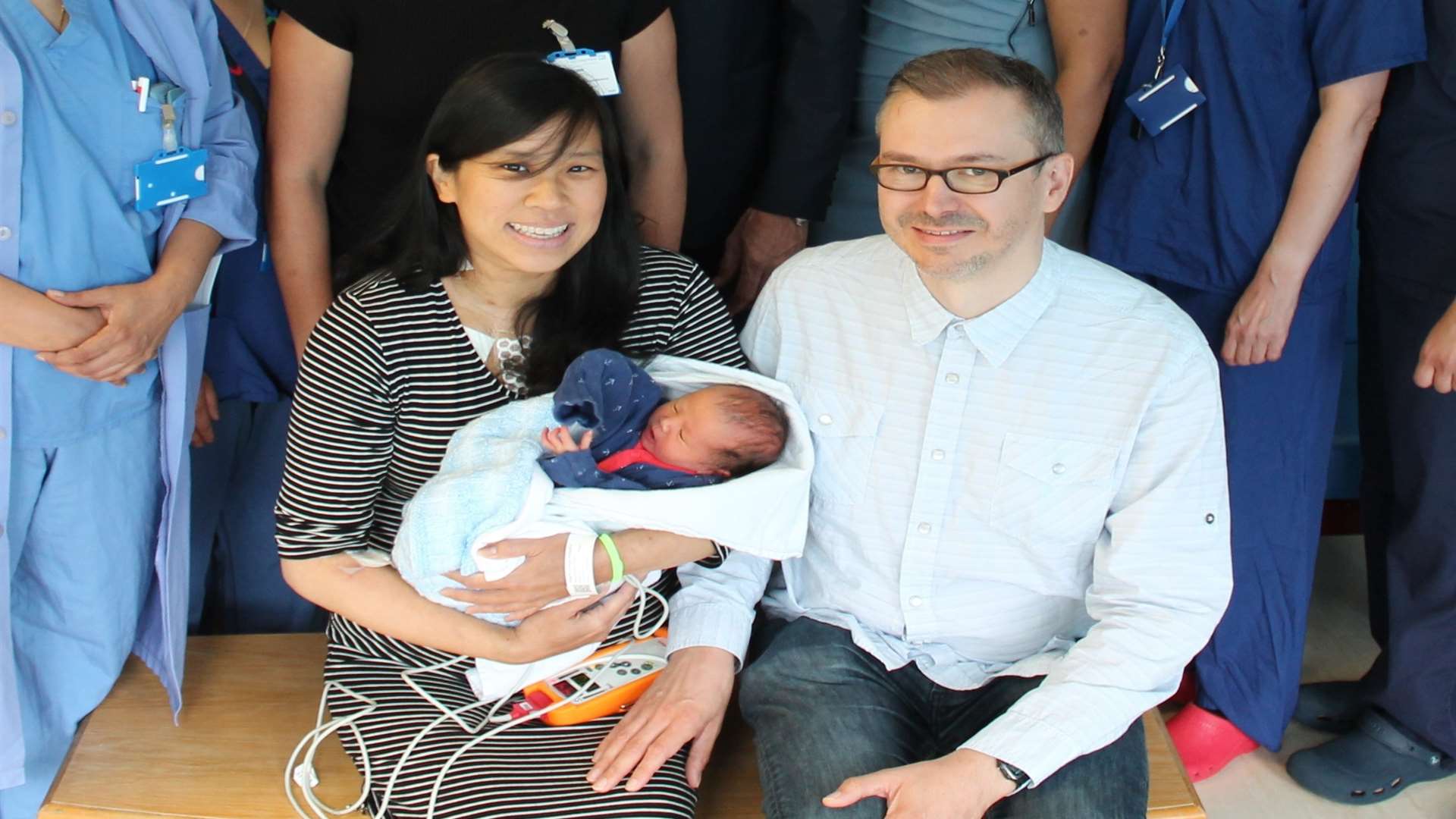 Margaret Wang with her new baby and her partner Peter Warren. Both mum and baby are doing well after the operation
