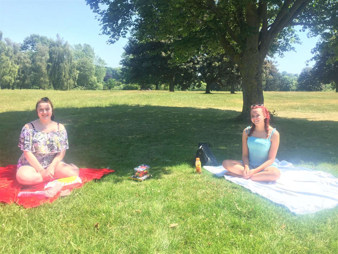 Amy Irwin and Abigail Bascall Kelly, both 16 from Maidstone, soak up the sun at Mote Park